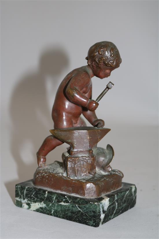 Henri Capy. A bronze figure of a putto forging an arrow, 6in.